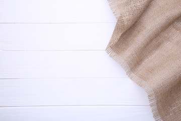 Natural sackcloth on white wooden background. Canvas on white wooden table