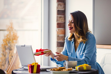 Beautiful young businesswoman have a coffee break while sitting indoors at home in Christmas time. Concept of work with startup business in Holiday time