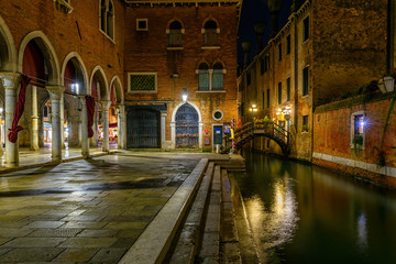 Fototapeta na wymiar Narrow canal with bridge in Venice, Italy. Architecture and landmark of Venice. Night cozy cityscape of Venice.