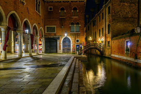 Narrow canal with bridge in Venice, Italy. Architecture and landmark of Venice. Night cozy cityscape of Venice.