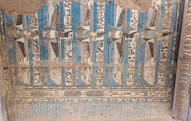 Painted hieroglyphic carvings on an ancient egyptian temple wall