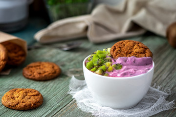 Healthy breakfast. Blueberry yogurt, biscuits and kiwi on a wooden table. Bright photo.