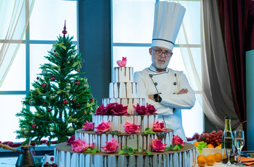 Cook and big cake in the festive kitchen