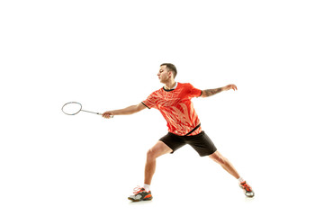 Young man playing badminton over white studio background. Fit male athlete isolated on white. badminton player in action, motion, movement. attack and defense concept - obrazy, fototapety, plakaty