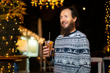 Happy man holding traditional fritula at Christmas market. Zagreb, Croatia