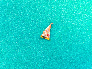 Aerial view of woman floating on inflatable pizza mattress, sunbathing. - 238183335