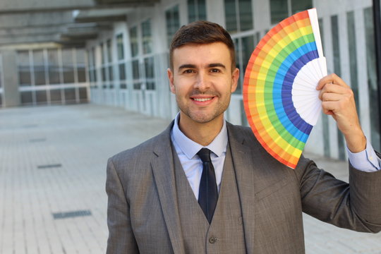 Businessman holding rainbow hand fan