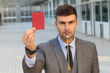 Businessman with whistle and red card