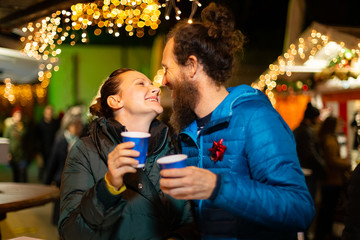 Couple kissing and enjoying traditional Christmas market, Zagreb, Croatia.