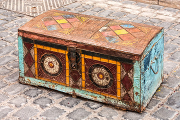 Ancient Oriental chest for storing clothes and fabrics. Ornament and pattern in Oriental style. Stands on a cobblestone pavement in Baku, Azerbaijan.