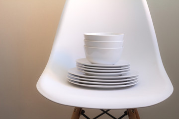 Fototapeta na wymiar white dishes on a white chair.