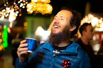Happy man holding traditional drink at Christmas market. Zagreb, Croatia.