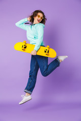 Beautiful young woman posing isolated over purple background wall. © Drobot Dean