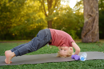 Little boy doing stretch during workout outdoors