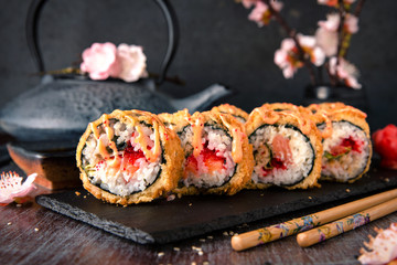 Hot fried Sushi Roll with salmon, eel, calf caviar and cheese. Sushi menu. Japanese food. Hot fried Sushi Roll