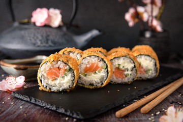 Hot fried Sushi Roll with salmon, avocado and cheese. Sushi menu. Japanese food.