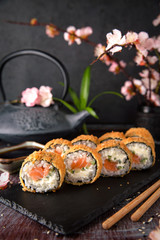 Hot fried Sushi Roll with salmon, avocado and cheese. Sushi menu. Japanese food.