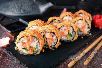 Hot fried Sushi Roll with salmon, shrimp, onion, avocado and cheese. Sushi menu. Japanese food.