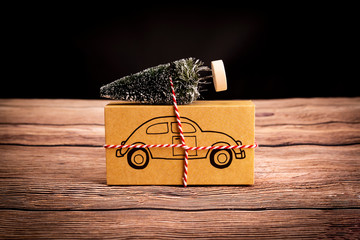 Prezent świąteczny. Świąteczny prezent z symbolem samochodu na drewnianym stole, kompozycja z...