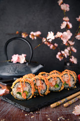 Hot fried Sushi Roll with salmon, shrimp, onion, avocado and cheese. Sushi menu. Japanese food.