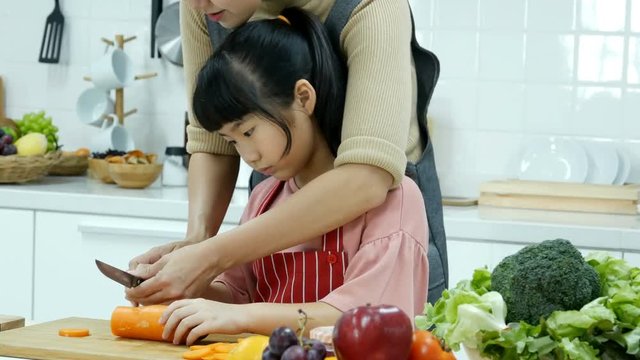 Little girl help her mother to preparing food at kitchen. Mother training little girl to preparing food. People lifestyle concept.