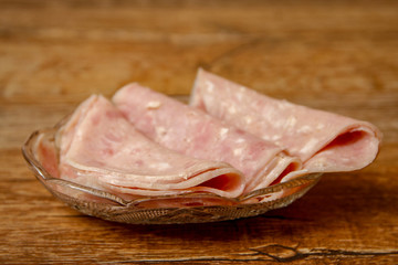 Sliced ham in crystal bowl on vintage wooden table