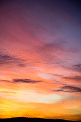 Dramatic sky with big clouds in the sunset. The sun is beautifully breaking through the clouds. Vertical