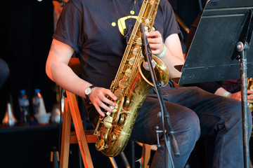 Musician playing saxophone at live concert on the stage