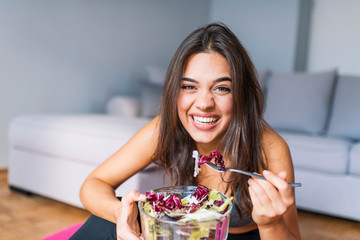 Fit woman eating healthy salad after workout