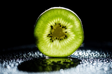 slice of fresh kiwi fruit on black background with bokeh - Powered by Adobe
