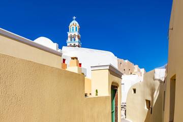 The beautiful narrow colorful streets of Emporio, Santorini, Greece with church towers where you...