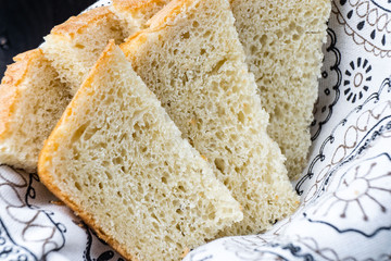 Fresh homemade baked bread and sliced bread on rustic white wooden table