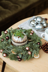 Decorative houseplants in winter. Florarium with fresh flowers on the table in a bright living room, decorated for Christmas.