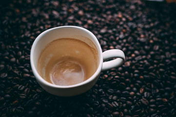 Empty coffee mug on coffee beans