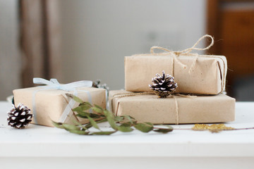 Obraz na płótnie Canvas boxes wrapped in Kraft paper with gifts beautifully laid out and decorated with Christmas decorations in the interior