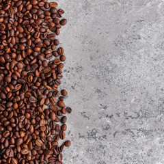 Roasted coffee beans on stone background. Top view with copy space for your text. Flat lay..