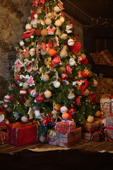 Red-brown Christmas attic interior with Christmas tree, fireplace, gifts.