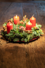 advent wreath and two burning red candles on a wooden table Studio
