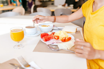 woman eating breakfast in hotel buffet