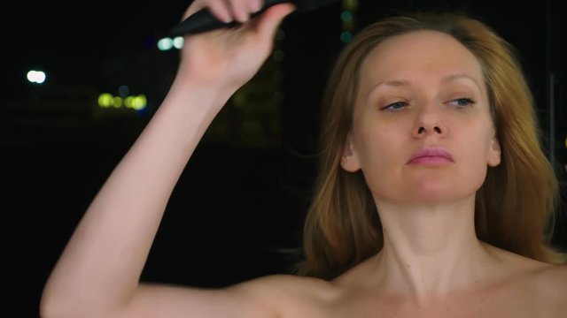 portrait of a young woman without make-up with bare shoulders against the blurry lights of the city. copy space