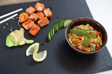 Poke bowls with salad and cucumber on the slate