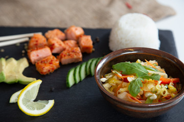 Poke bowls with salad and cucumber on the slate