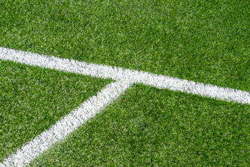 Green synthetic artificial grass soccer sports field with white corner stripe line