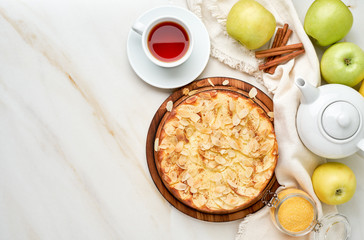Cheesecake, apple pie, curd dessert with polenta, apples, almond flakes and cinnamon on white...