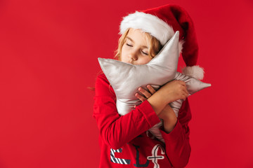 Cute little girl wearing Christmas hat standing
