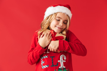 Cute little girl wearing Christmas hat standing
