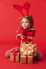 Pretty little girl wearing Christmas deer horns sitting