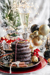 Christmas, xmas ginger bread with glass of champagne, rowan, mountain ash and sweets, cookies on red plate, golden balls and confetti with cinnamon, chrismas cone