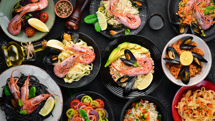 A set of seafood dishes on a black background. Pasta, bulgur, rice, couscous. Top view. Free space for your text.