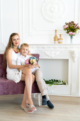 woman is sitting on the couch with her son and daughter